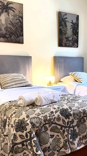 A hotel room with two beds, each with a headboard, a nightstand with a lamp, and artwork on the walls. - Refúgio do Atalho by Stayguest (Santana)