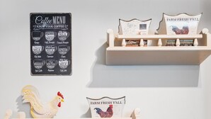 Eine Küche mit einer Spüle aus Edelstahl, einem Kaffeespezialitätenangebot und Dekoration, darunter ein Hahn und ein Schild mit der Aufschrift 'Farm Fresh Y'all'.