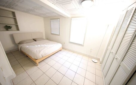 A bedroom with a bed, a window, and a wardrobe.