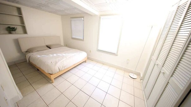 Un dormitorio con cama, ventana y armario.