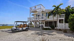 A two-story beachfront property with a golf cart parked in front. - Rooftop Deck · Heated Pool & Spa · 1 Min To Beach (Bradenton Beach)