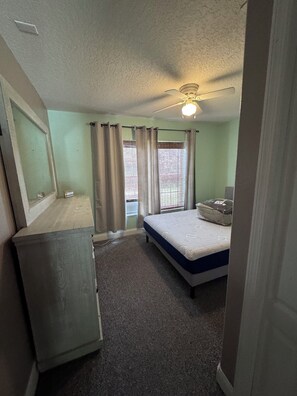 A bedroom with a single bed, a ceiling fan, and a window with curtains. - COZY LAKE FRONT 1-bedroom apartment, kitchen, balcony on East Lake TOHO. (St. Cloud)