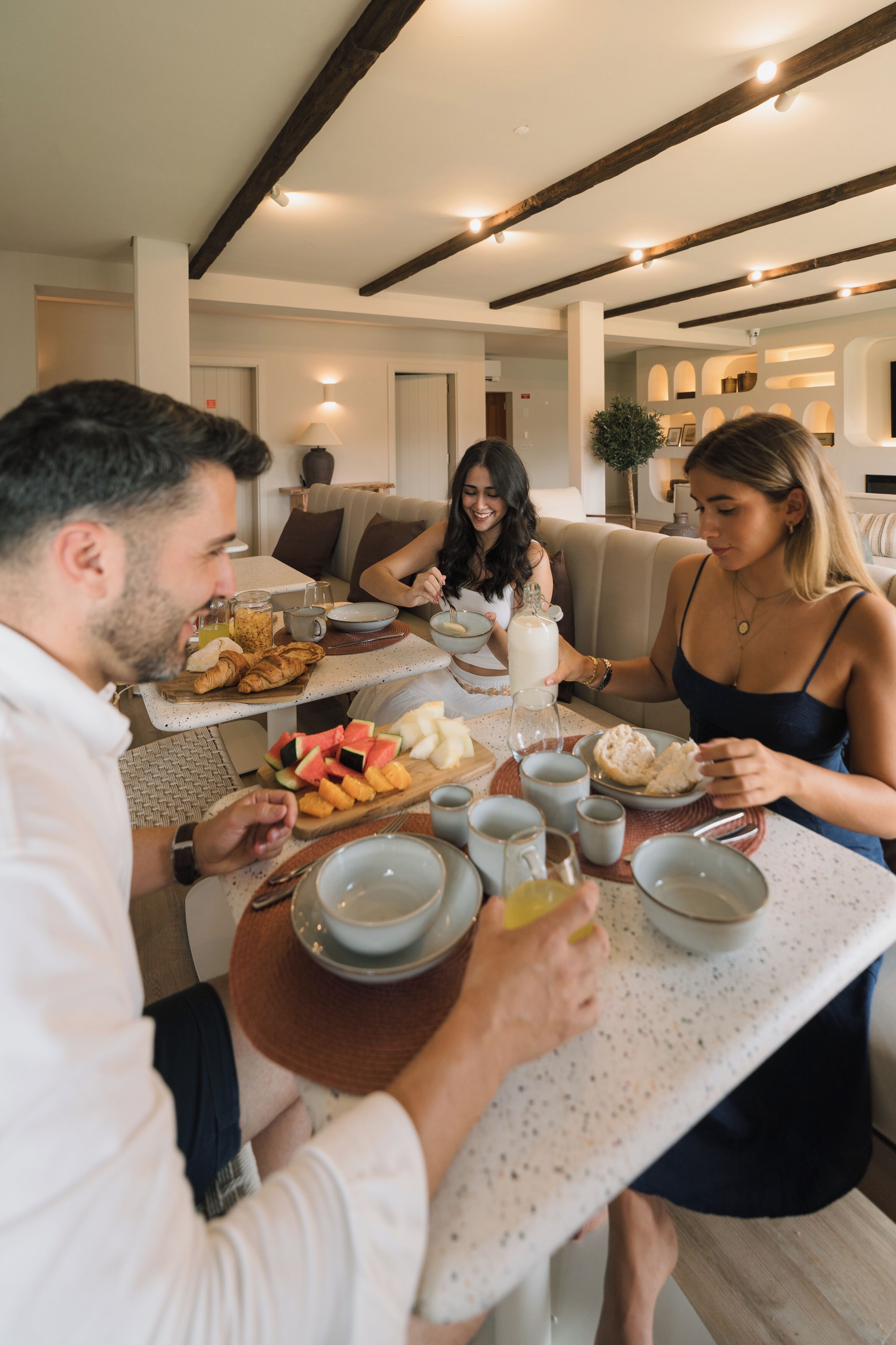 Un espace repas avec une table dressée pour quatre personnes, où l’on trouve une variété de plats et de boissons.