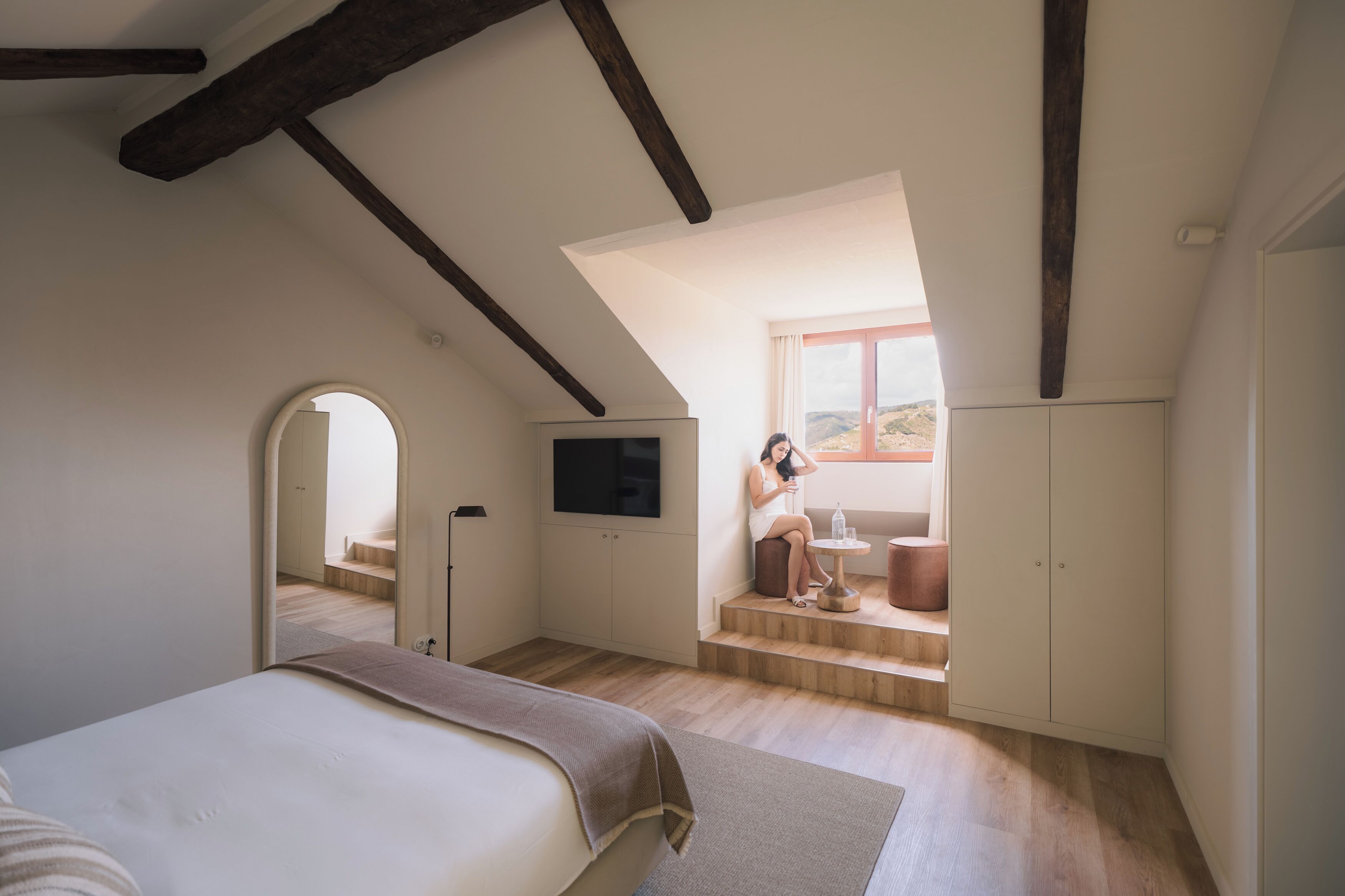 Une chambre à coucher avec un lit, une télévision, une fenêtre et une vue sur l’extérieur.