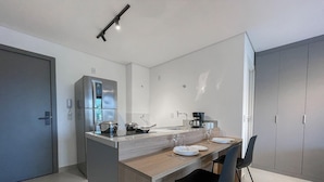 A modern kitchen with a central island, built-in appliances, and a dining area with chairs.