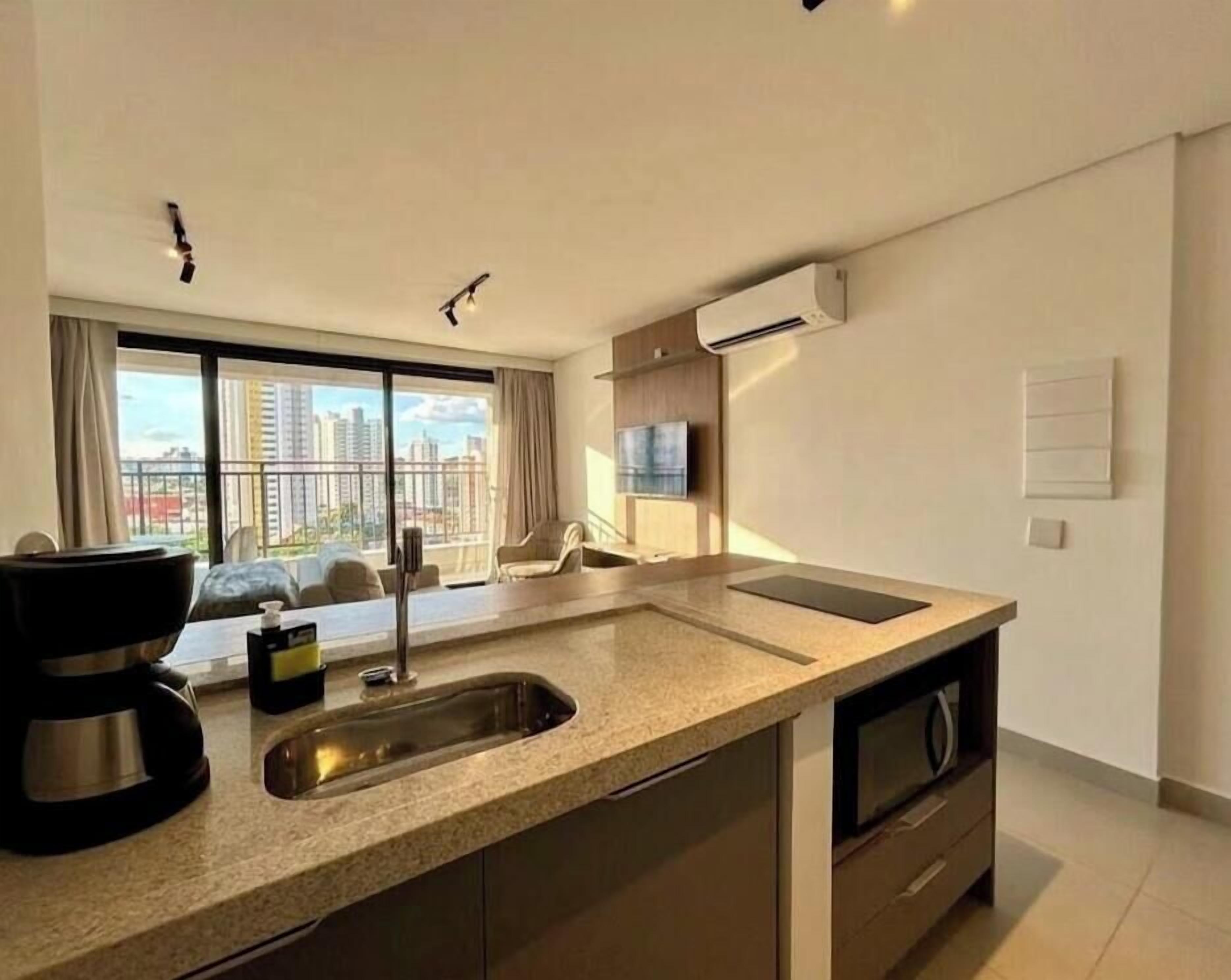 A modern kitchen with a large window, a built-in oven, and a sink.