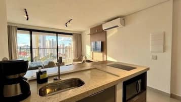 A modern kitchen with a large window, a built-in oven, and a sink.