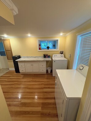 A laundry room with a washing machine, a dryer, and a window with a view of trees. - 3k square foot house-sleeps 12 people comfortably. (Coloma)