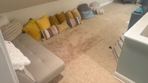Un salon avec un canapé, un fauteuil et un téléviseur.
