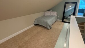 Une chambre à coucher avec un lit, un bureau et un grand miroir.