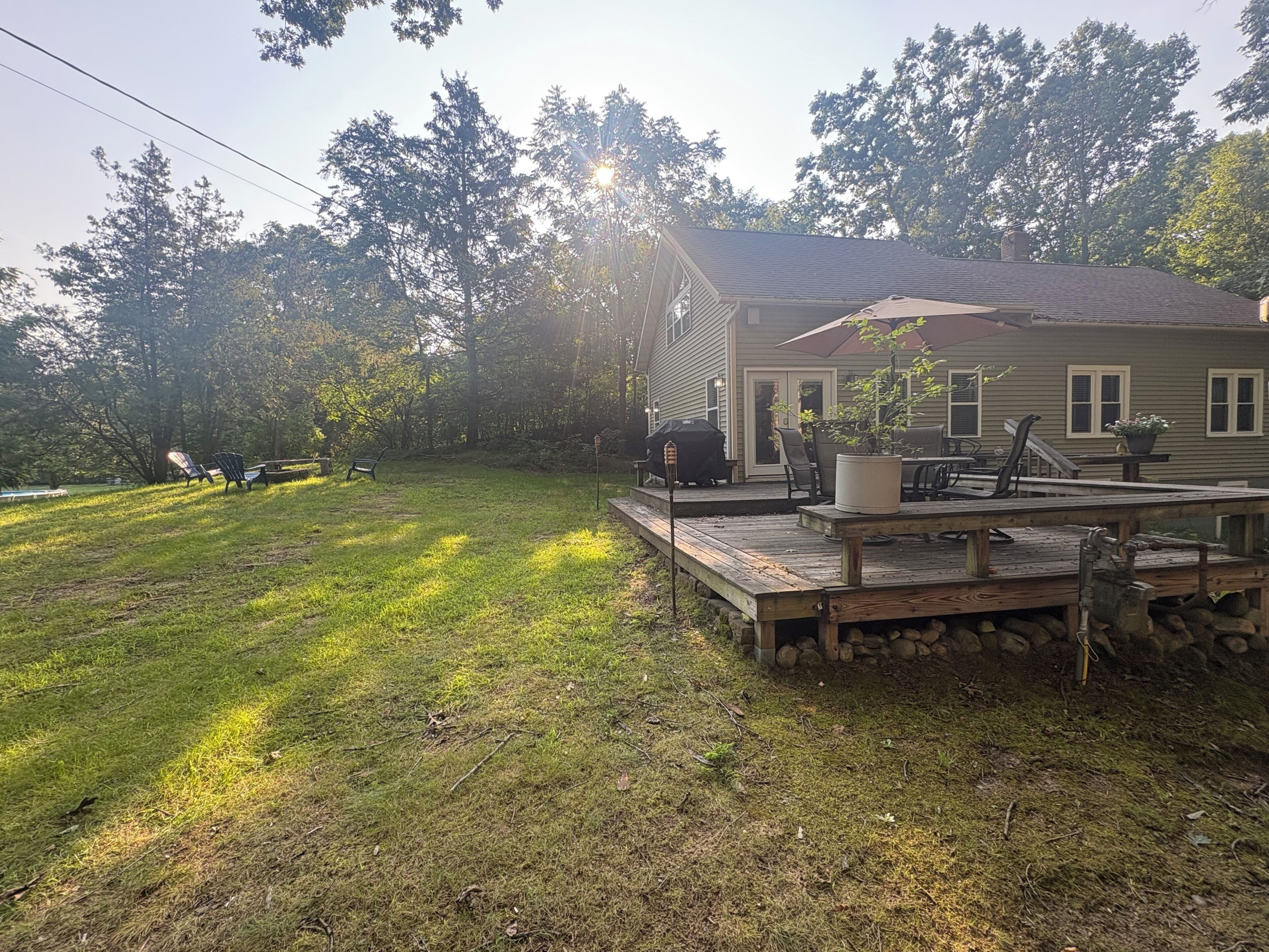 A house with a deck, outdoor furniture, and a grill.