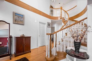 A staircase with wooden balusters and a curved design leading to an upper floor. - Spacious 4BR/4BA Vancouver Retreat | Near Downtown & UBC (Vancouver)