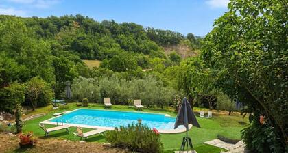 A 19th-century farmhouse with spacious grounds surrounded by greenery and a swimming pool