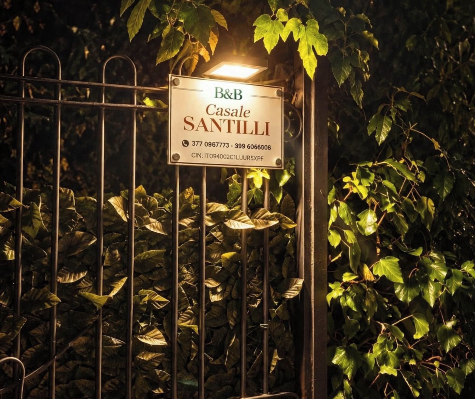 A metal gate with a sign for B&B Casale Santilli, including contact numbers and a CIN code.