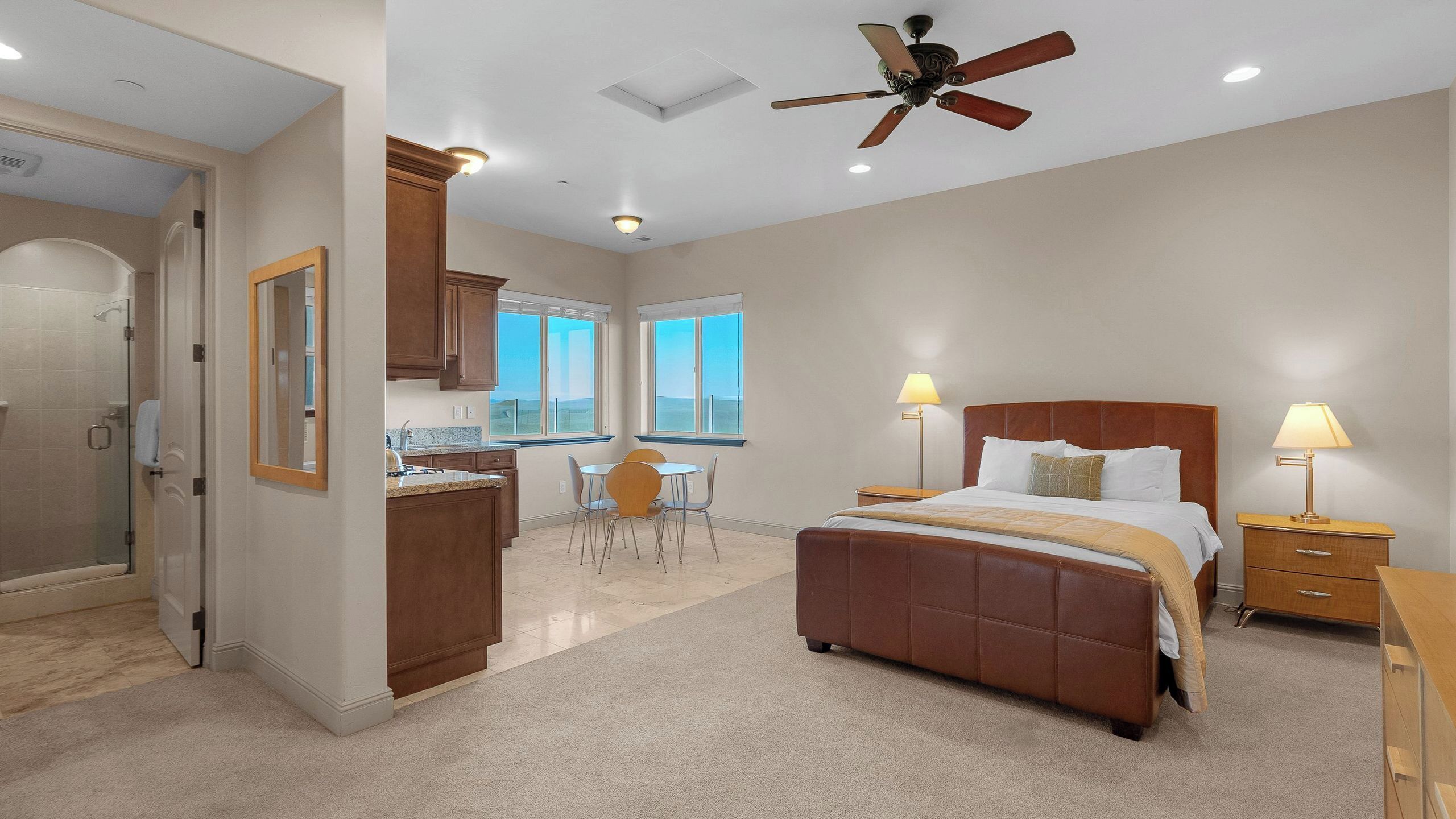 A bedroom with a bed, bedside tables, a desk, and a chair.