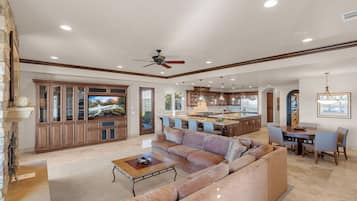 A spacious living room with a large sofa, a coffee table, and a television.