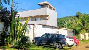 A two-story building with a flat roof and a car parked in front.