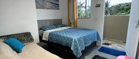 Un dormitorio con dos camas, una ventana, una puerta y un pequeño balcón.