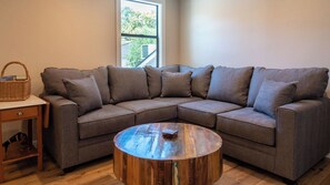 A modern living room with a sectional sofa, a wooden coffee table, and a small side table with a basket. - The Top Shelf by Avantstay Two Master Suites + Balconies Downtown Paso Robles Wine Country (Paso Robles)
