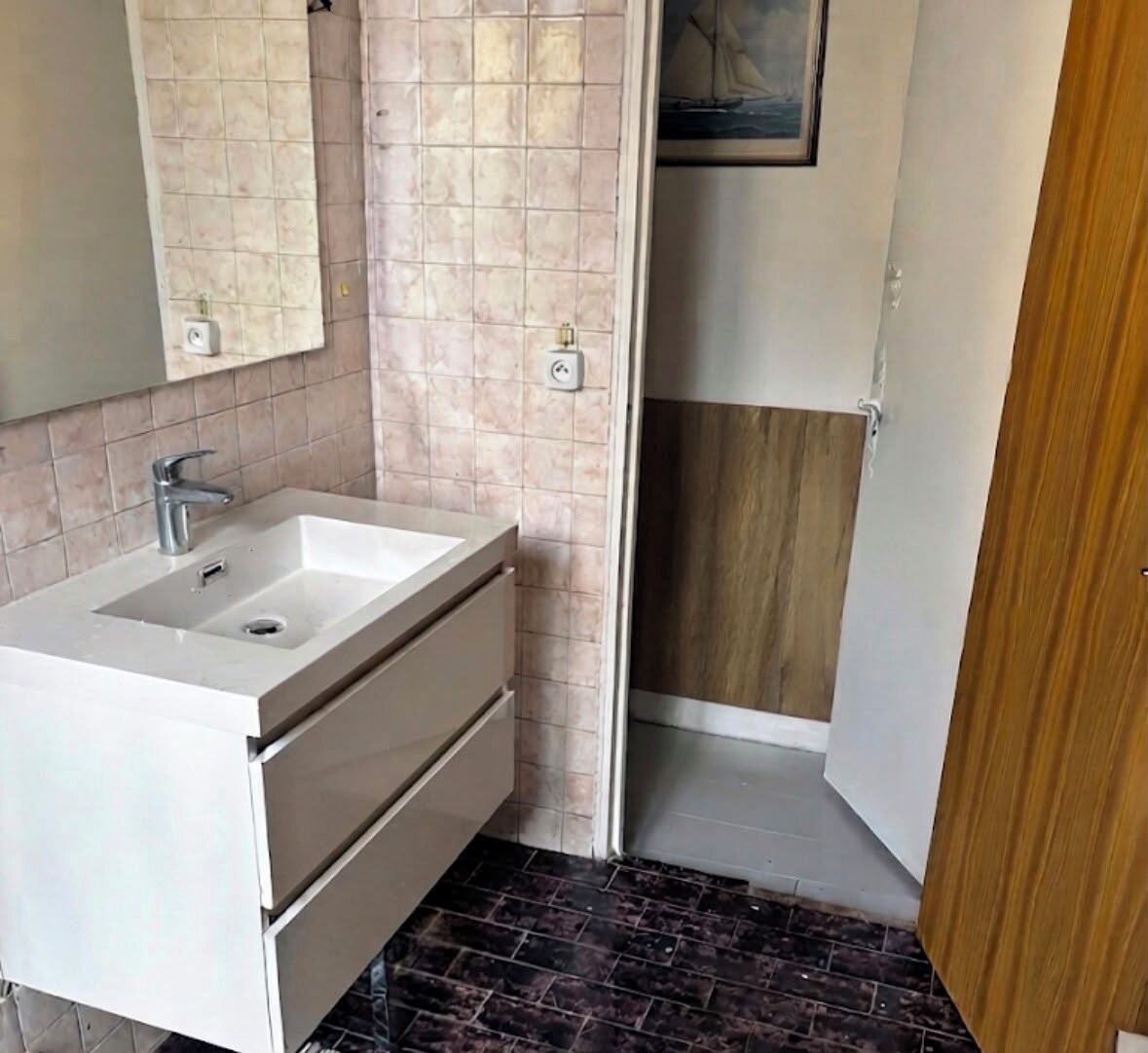 Ein Badezimmer mit Waschbecken, Spiegel und Duschbereich.
