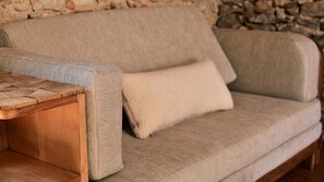 Un sofá color beige con tela texturizada y una mesita de madera.