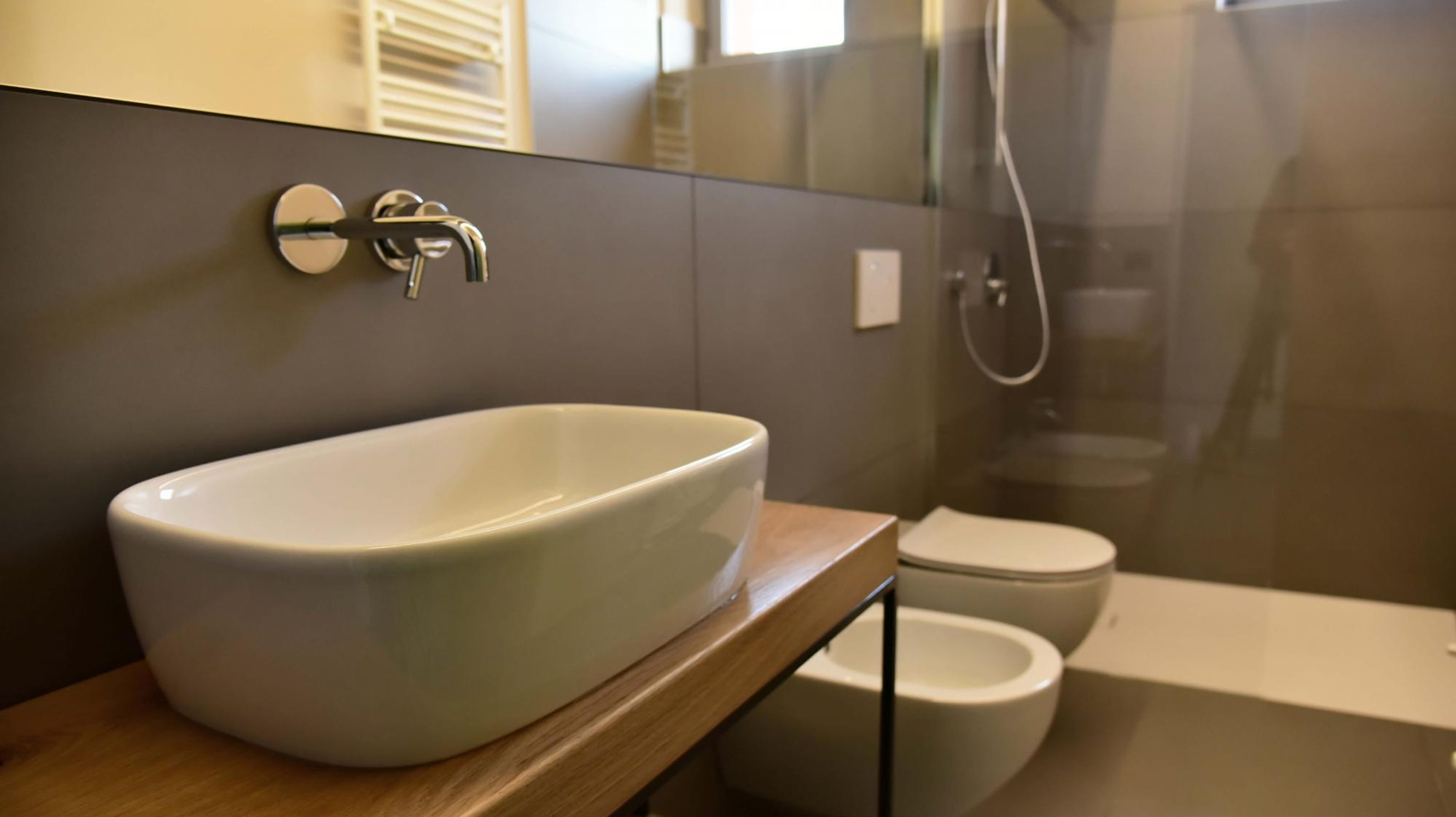 Ein Badezimmer mit einem Aufsatzwaschbecken, einer Toilette und einer Dusche.