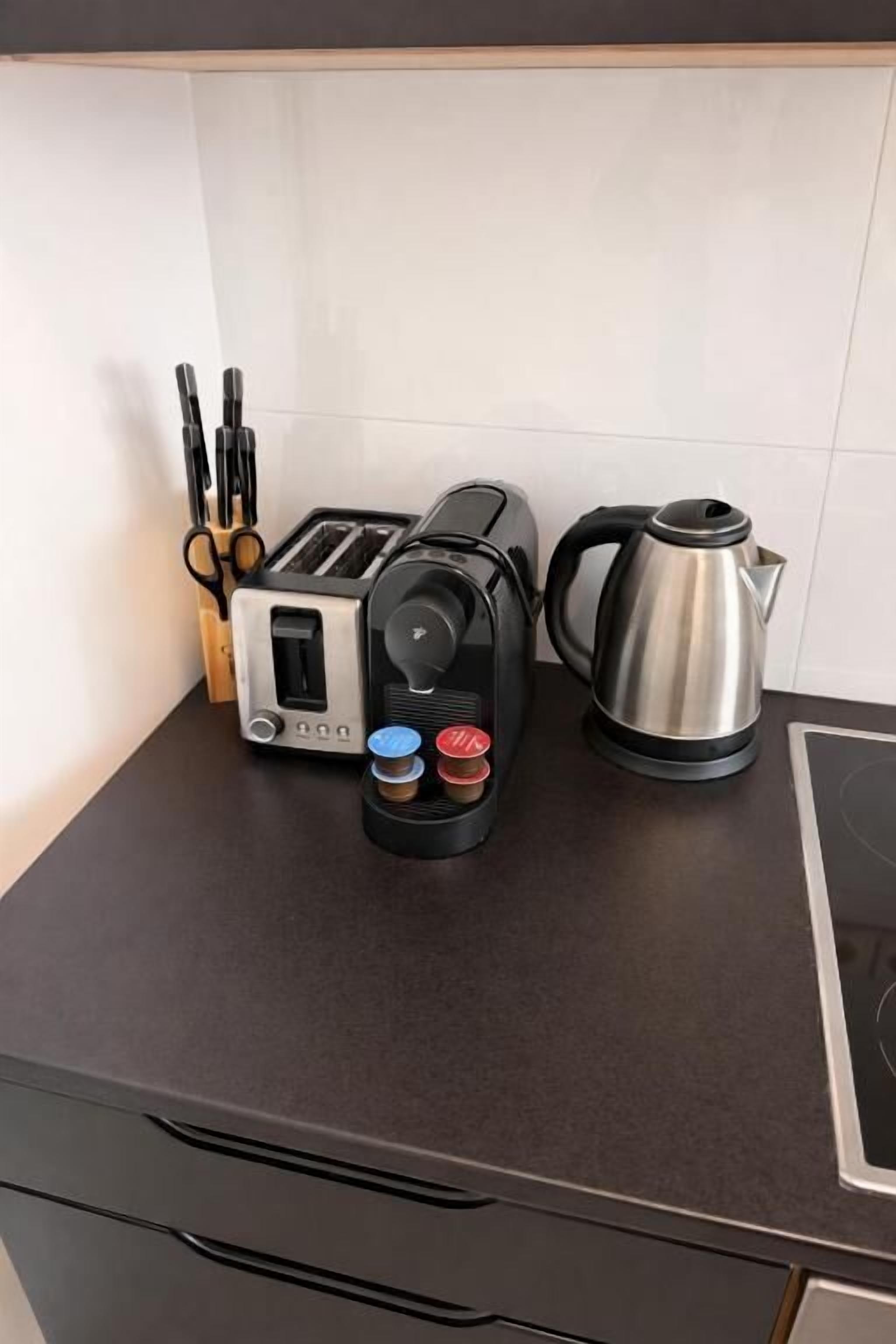 Een aanrecht met een broodrooster, een waterkoker en een koffiezetapparaat.