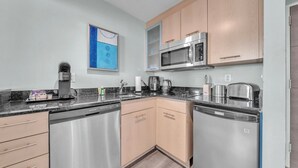 Una cucina moderna con elettrodomestici in acciaio inossidabile, mobili in legno e un piano di lavoro con diversi oggetti.