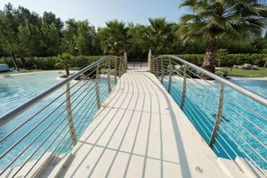 A pool area with a walkway and palm trees. - 22 Relais du Lac Elite - Italian Homing (Desenzano del Garda)