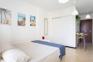 A bedroom with a bed, a bedside table, a mirror, and a door. - Home2Book Sea View Studio & Pool, Caletillas (Las Caletillas)
