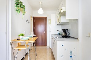 A compact kitchen with a wooden table, a sink, and a coffee maker. - Home2Book Sea View Studio & Pool, Caletillas (Las Caletillas)