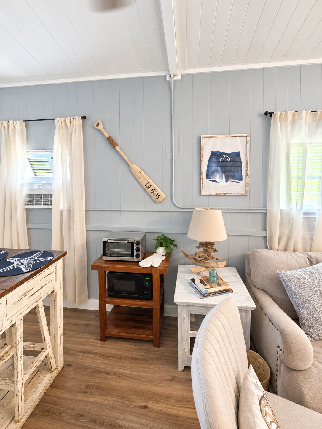 En hyggelig opholdsstue med et træbord, en sofa, en lampe og et vægmonteret flag.