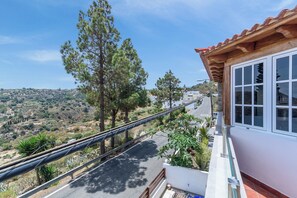 Un balcon offrant une vue sur une route sinueuse et le paysage environnant.