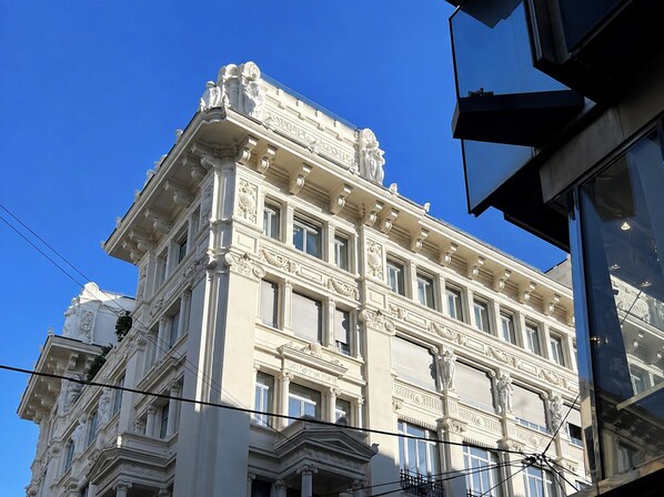 Un edificio clásico con detalles arquitectónicos ornamentados, que incluyen estatuas y columnas.