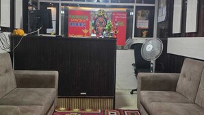 A reception area with a reception desk, two sofas, a patterned carpet, and a ceiling with blue lighting. - Tanish Stay Inn (Bengaluru)