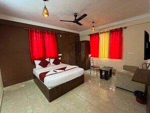 Ein Hotelzimmer mit einem Bett, einem Sessel, einem kleinen Tisch und einem Fernseher.