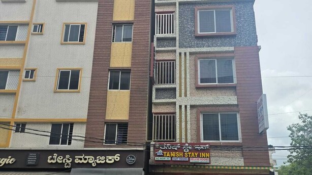 A multi-story building with a ground-level restaurant and a hotel above. - Tanish Stay Inn (Bengaluru)