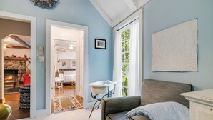 A room with a fireplace, a bathtub, and a large window with curtains.