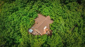 Vista aérea de uma casa rodeada por folhagem verde exuberante.