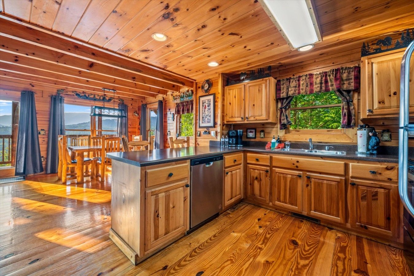 L’intérieur d’un chalet en bois comprend une cuisine, un coin repas et offre une vue sur l’extérieur.
