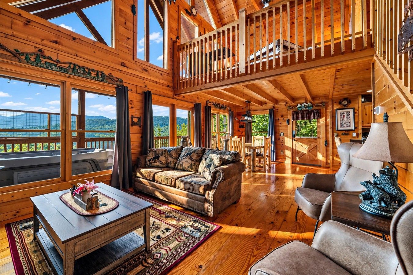 A spacious wooden cabin with a balcony, a cozy living area with a sofa and chairs, and a dining table.