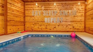 Eine Holzjagdhaushütte mit Whirlpool und einer Holzwand mit Schrift.