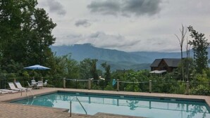 Ein Pool mit Liegestühlen und Blick auf Berge.