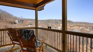 Eine Holzterrasse mit einem Schaukelstuhl und Blick auf eine Wohngegend.