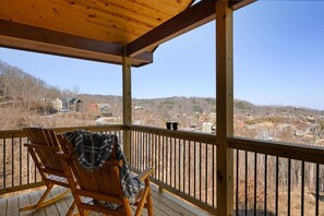 Eine Holzterrasse mit einem Schaukelstuhl und Blick auf eine Wohngegend.