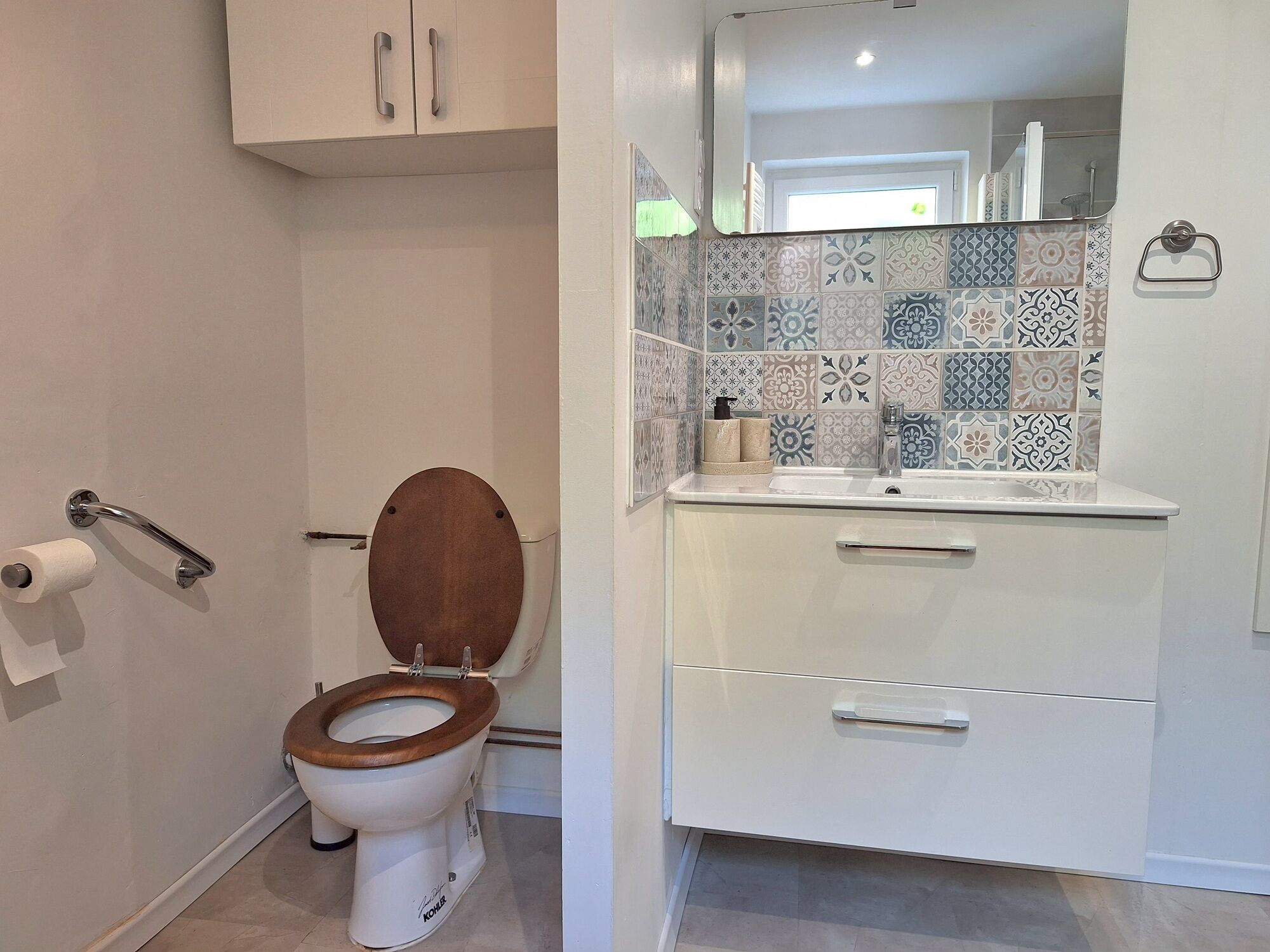 Un baño con inodoro, lavamanos y espejo.