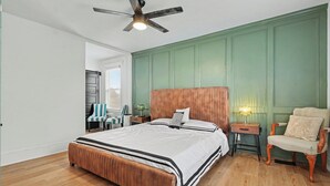 A bedroom with a bed, a chair, a nightstand, a lamp, and a ceiling fan. - Luxurious curated high end oasis (Cincinnati)