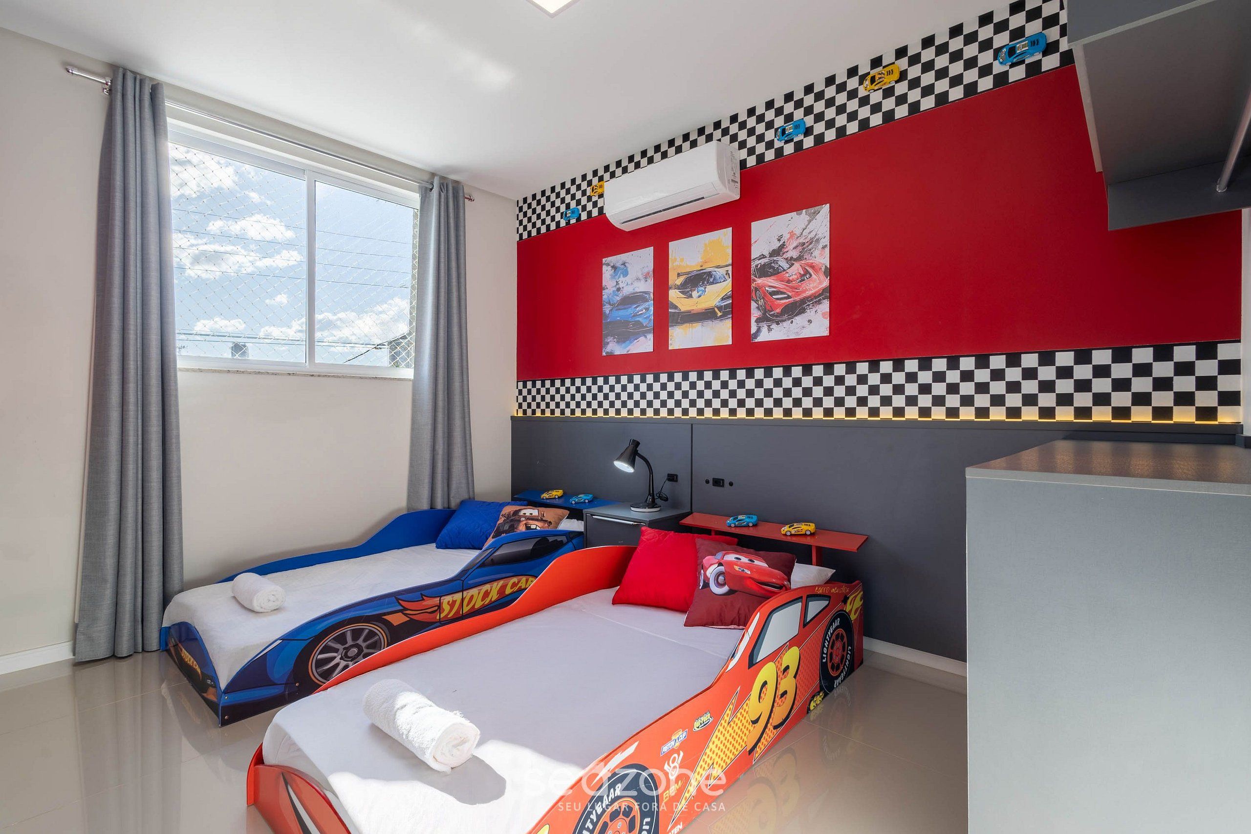 Un dormitorio con dos camas, un escritorio y una ventana.
