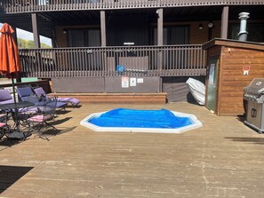 Eine Terrassenausstattung im Freien mit Whirlpool, Liegestühlen und Grill.