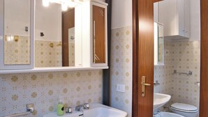 Un baño con un lavabo blanco, un espejo y un inodoro.